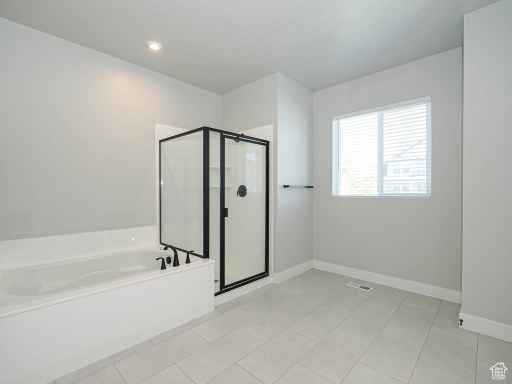 Bathroom with a garden tub, a shower stall, and tile patterned floors
