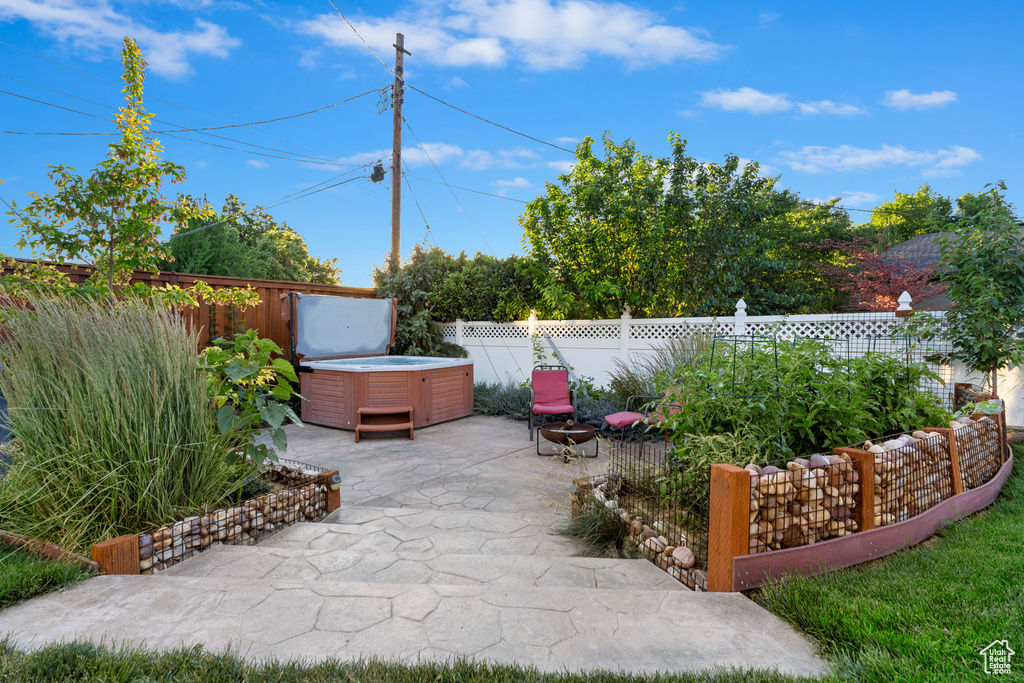 Fenced backyard featuring a hot tub and a patio area