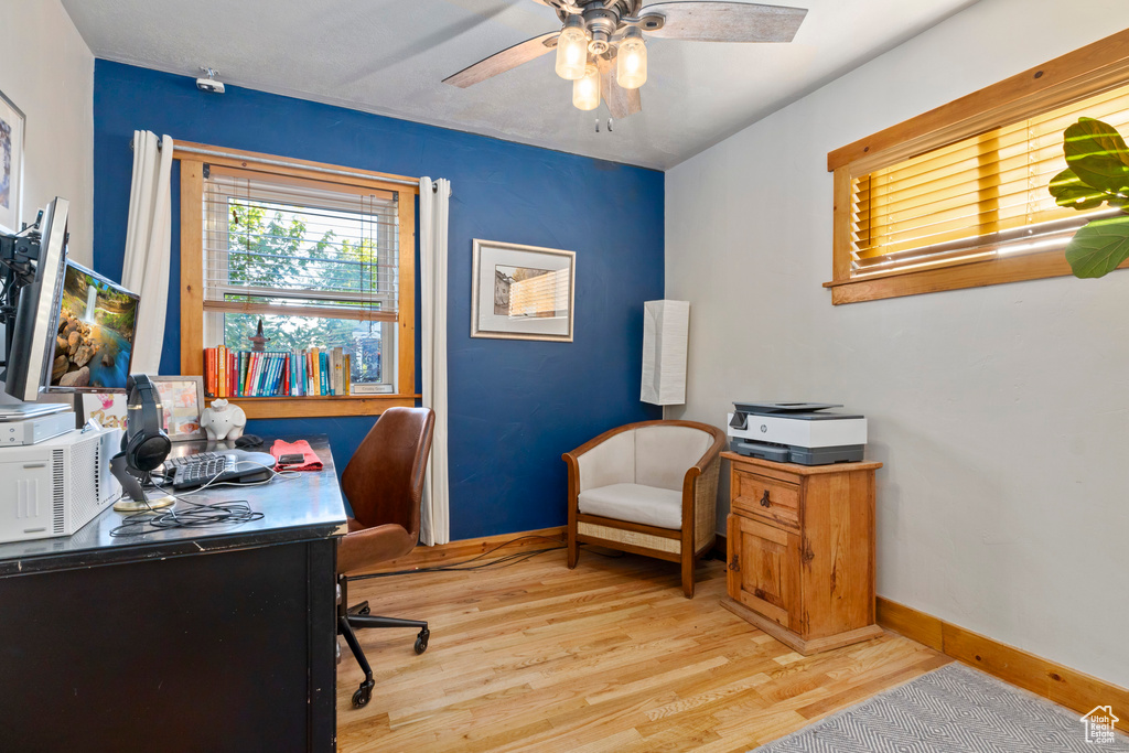 Home office featuring light wood-style floors and a ceiling fan