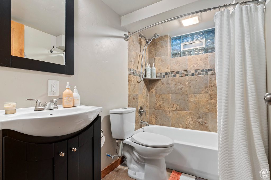 Bathroom featuring shower / tub combo with curtain, vanity, and tile patterned flooring