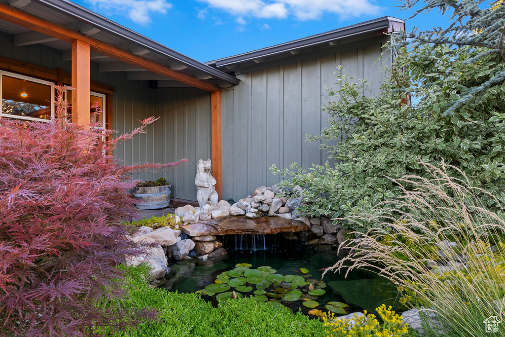 View of side of property with a small pond
