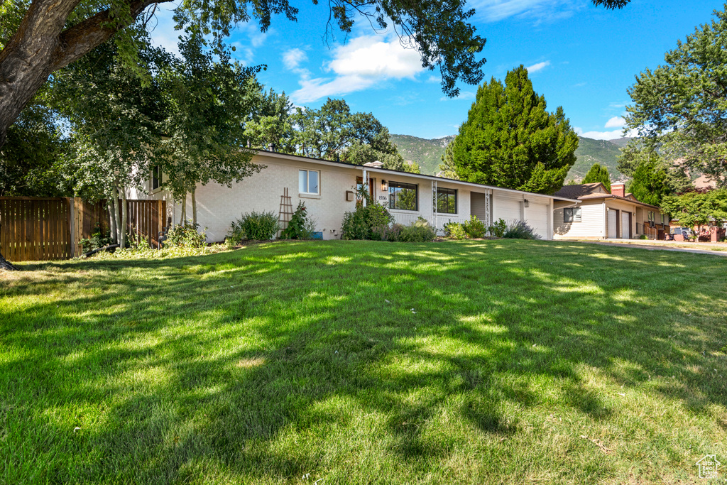 Ranch-style home with a garage, a mountain view, and brick siding