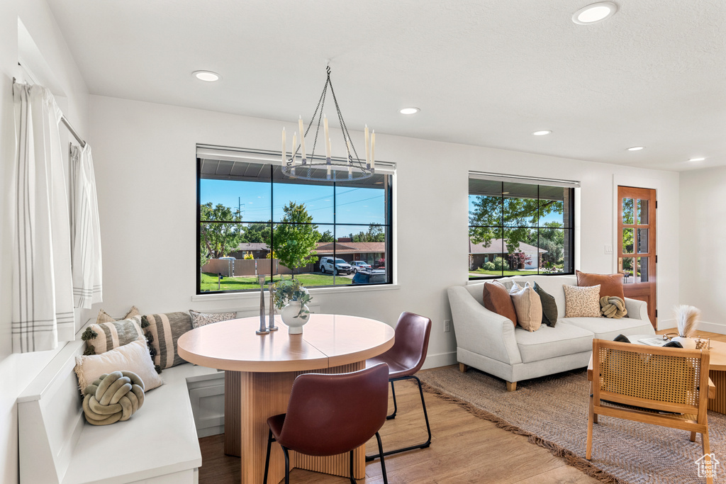 Dining room with light wood-type flooring, a chandelier, and recessed lighting