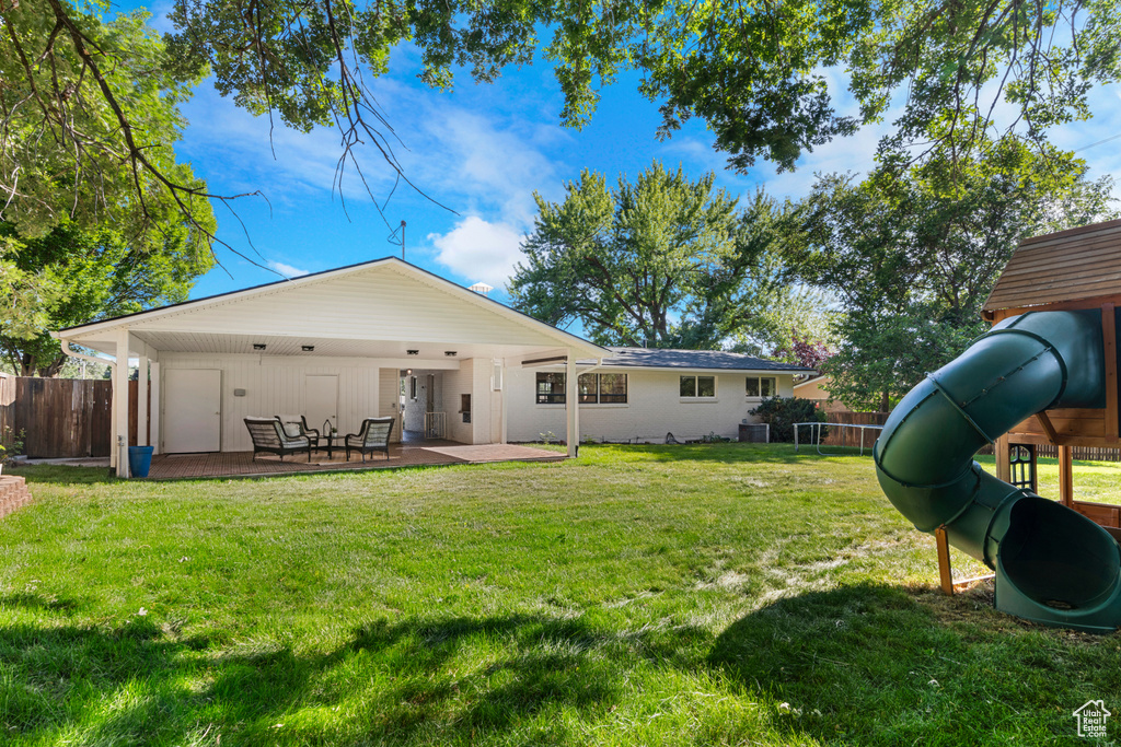Rear view of property with a patio area and a playground