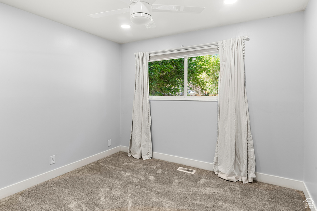 Carpeted spare room featuring ceiling fan and recessed lighting