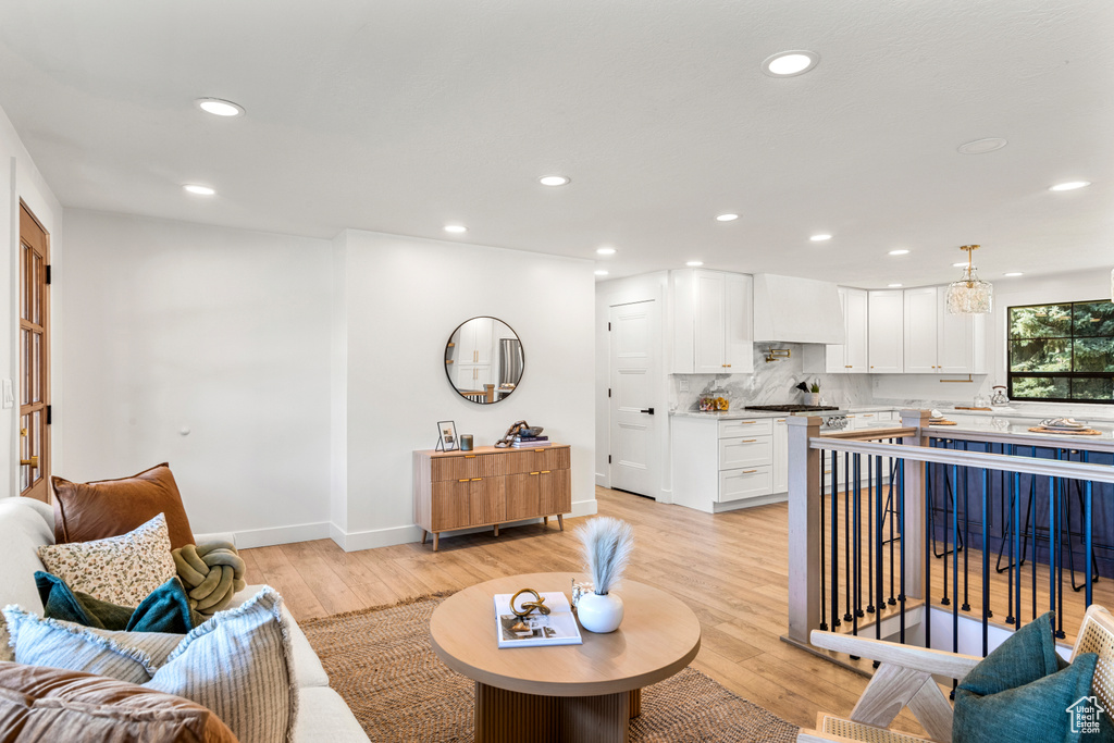 Living area with light wood finished floors and recessed lighting