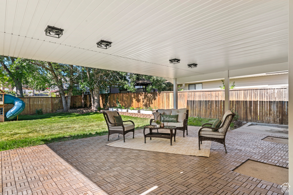 Fenced backyard featuring a patio, an outdoor living space, and a playground