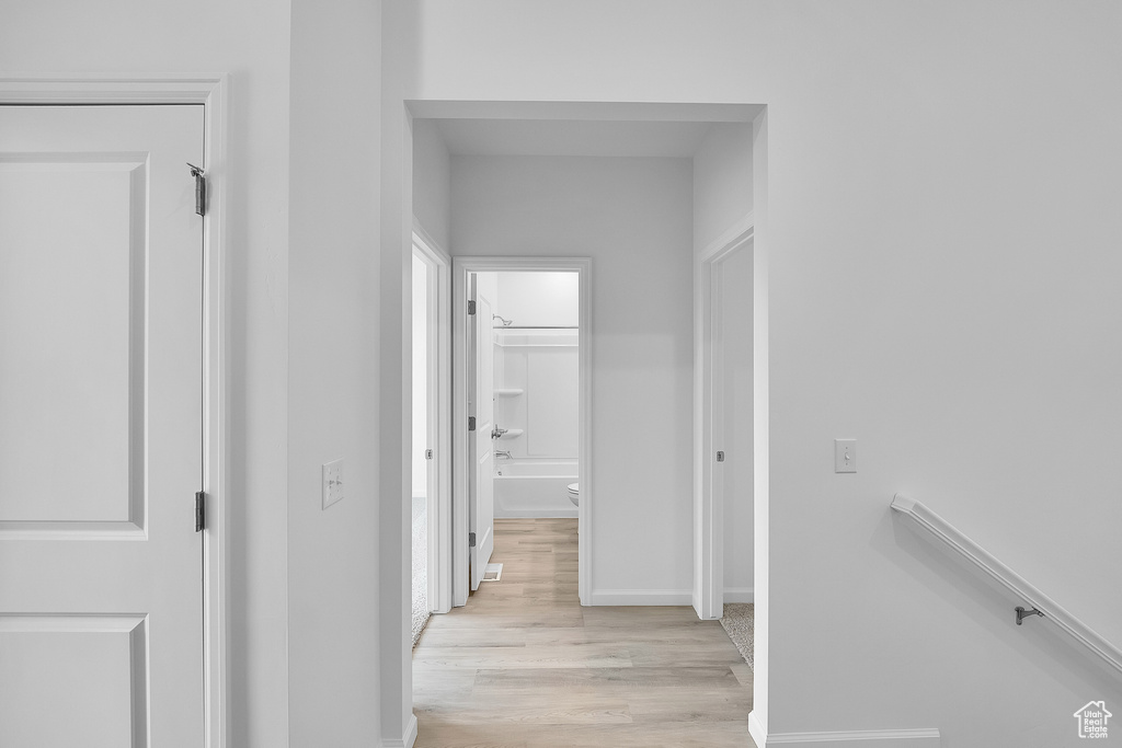 Hallway featuring light wood-style floors and baseboards