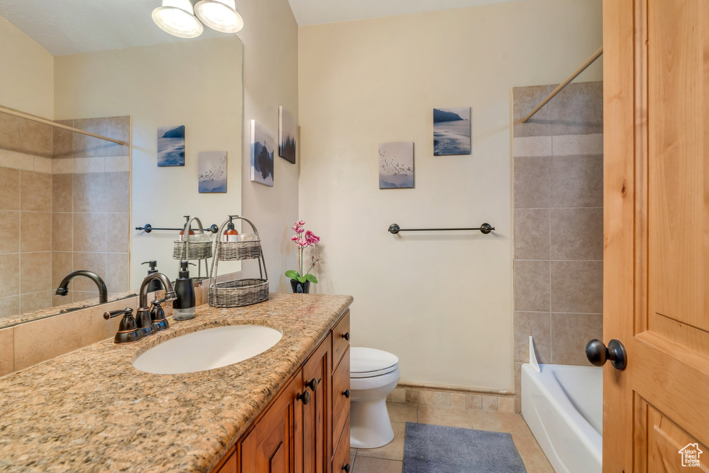Full bath with vanity, tile patterned flooring, and shower / washtub combination