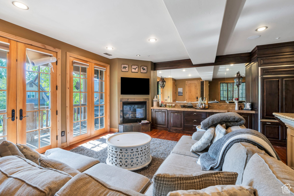 Living room featuring dark wood-style flooring, french doors, recessed lighting, and beam ceiling