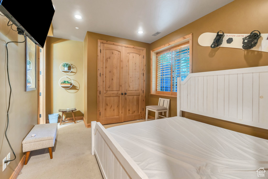 Bedroom with light colored carpet and recessed lighting