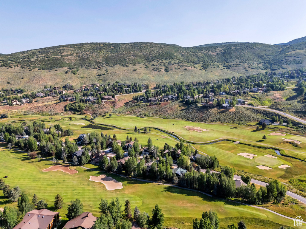 Aerial view of property and surrounding area featuring a mountain backdrop and a local golf course