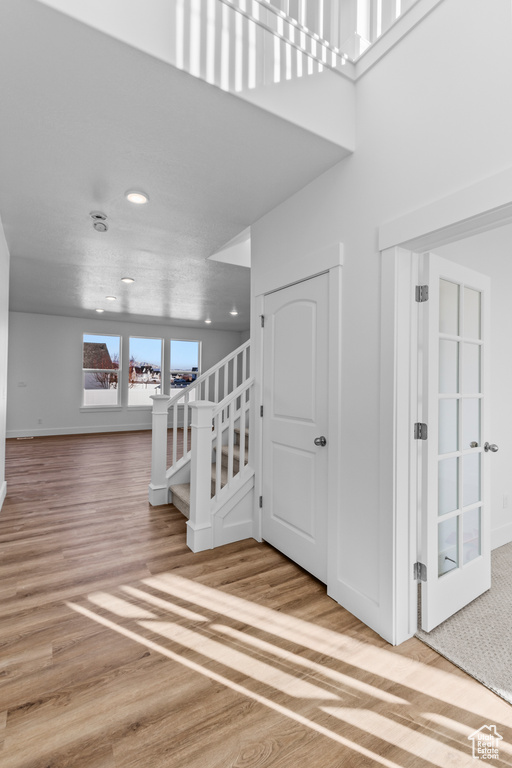 Stairway with wood finished floors and recessed lighting