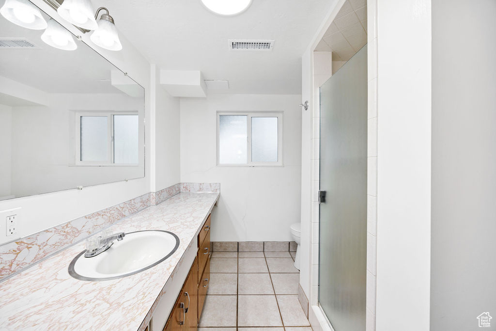 Bathroom featuring vanity, a stall shower, and tile patterned floors
