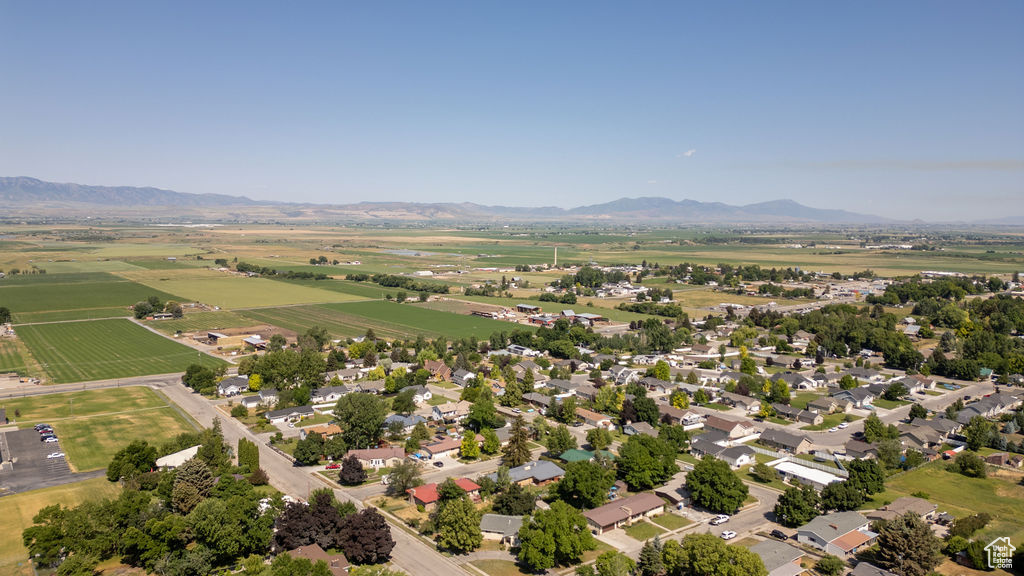 Aerial view of property and surrounding area featuring a mountain backdrop