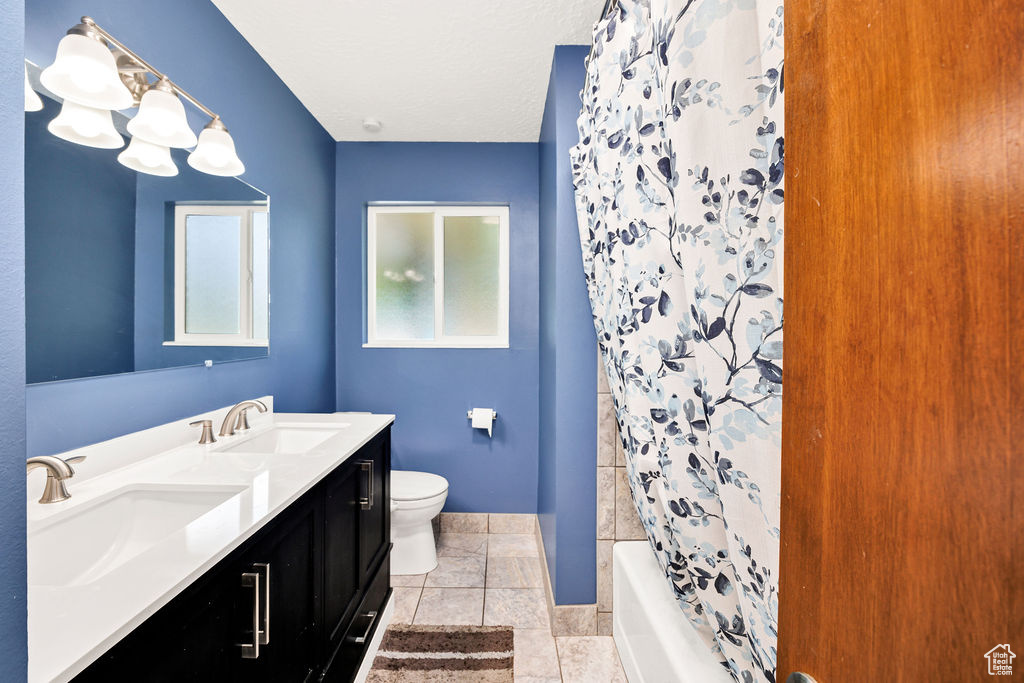 Full bath with double vanity and shower / bath combination with curtain