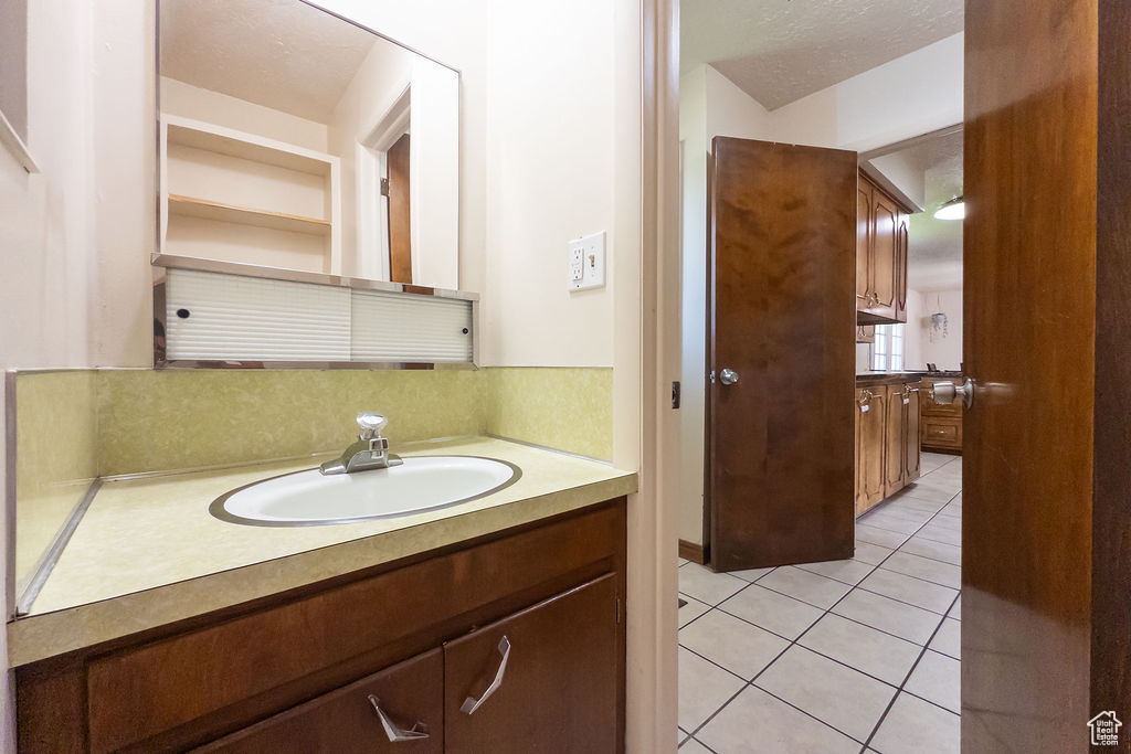 Bathroom with tasteful backsplash, vanity, and tile patterned flooring