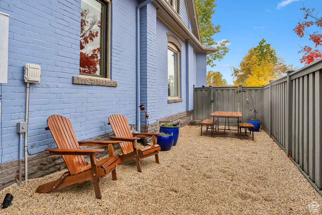 View of home\'s exterior with brick siding and a fenced backyard