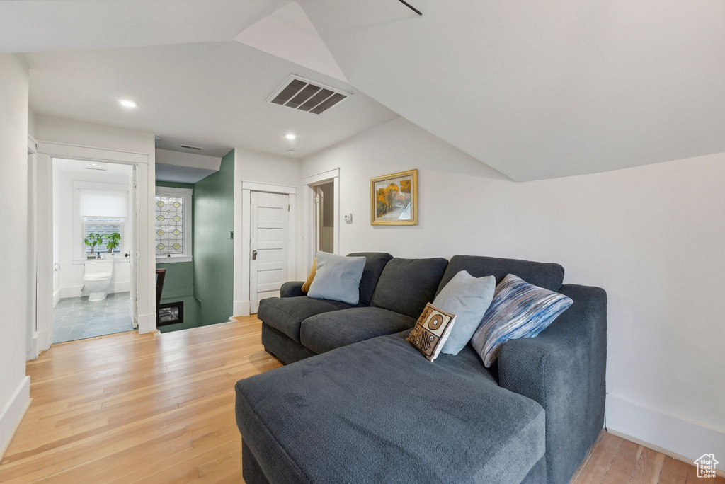 Living room featuring light wood-type flooring, recessed lighting, and vaulted ceiling