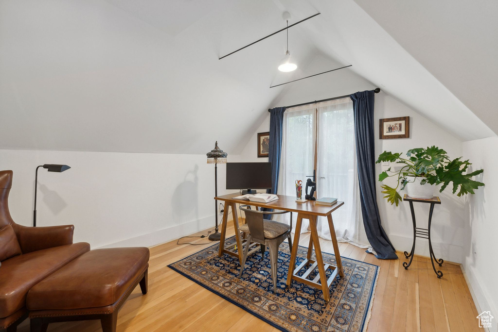 Home office with lofted ceiling and light wood-type flooring