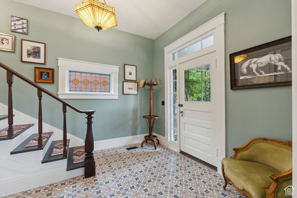 Entrance foyer with stairway and baseboards