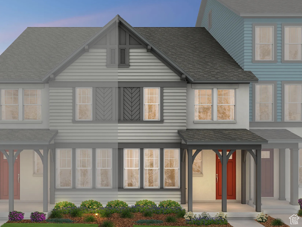 View of front of house with a front yard and a shingled roof