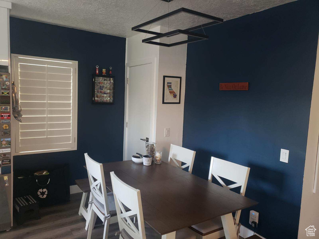 Dining space with wood finished floors and a textured ceiling