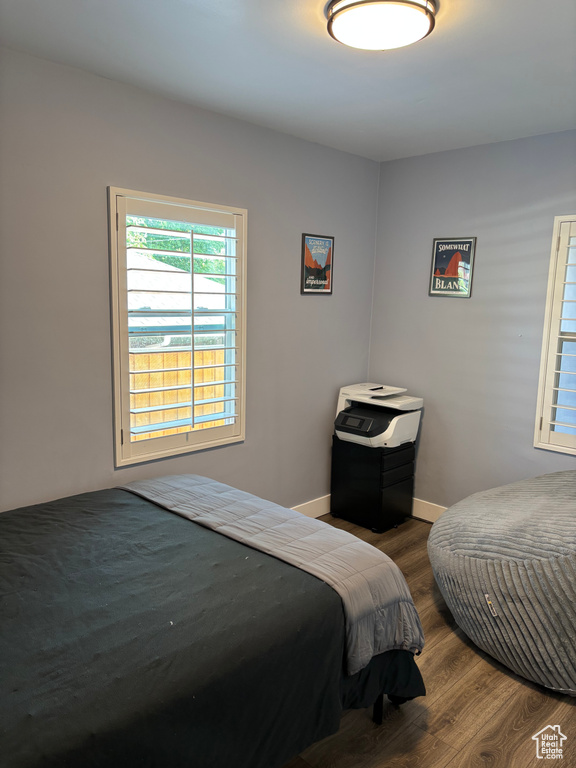 Bedroom with wood finished floors and baseboards
