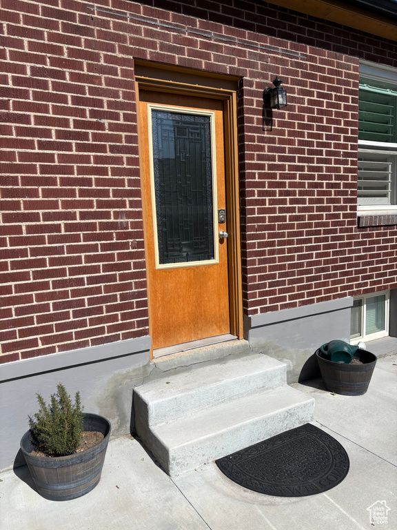 Doorway to property featuring brick siding
