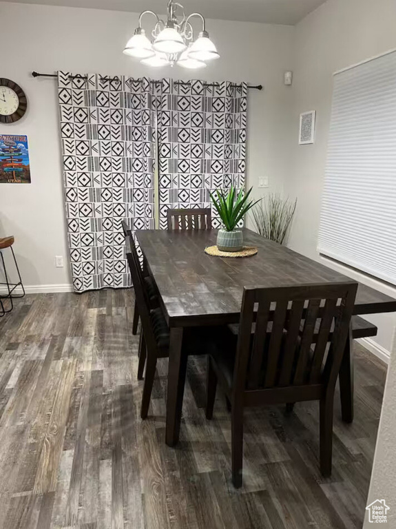 Dining space featuring wood finished floors and a chandelier