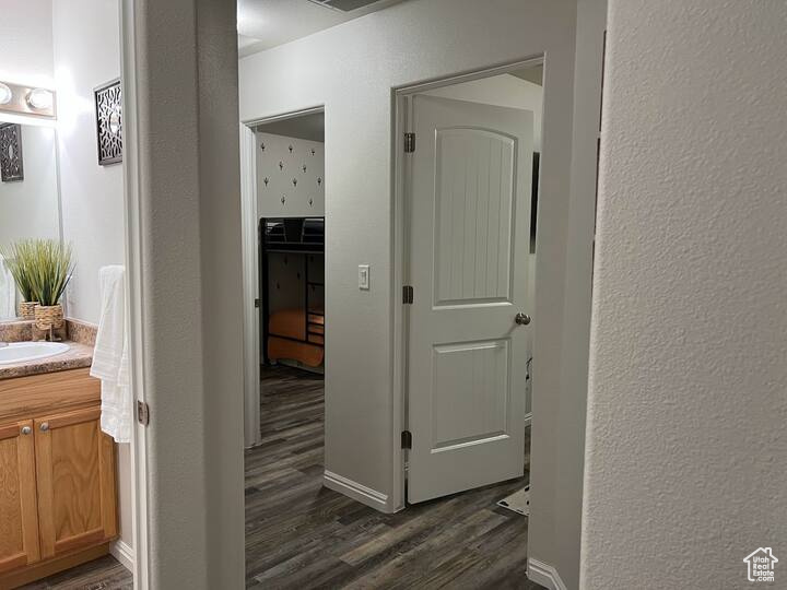 Corridor with dark wood finished floors and a textured wall