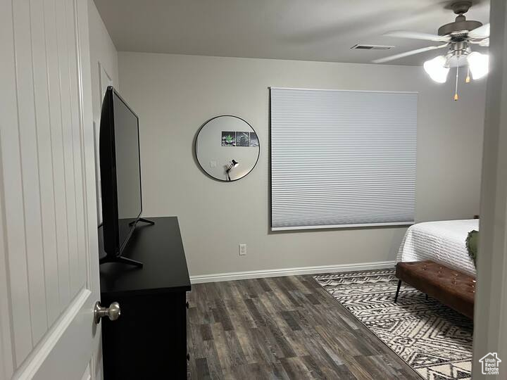 Bedroom with dark wood finished floors and a ceiling fan