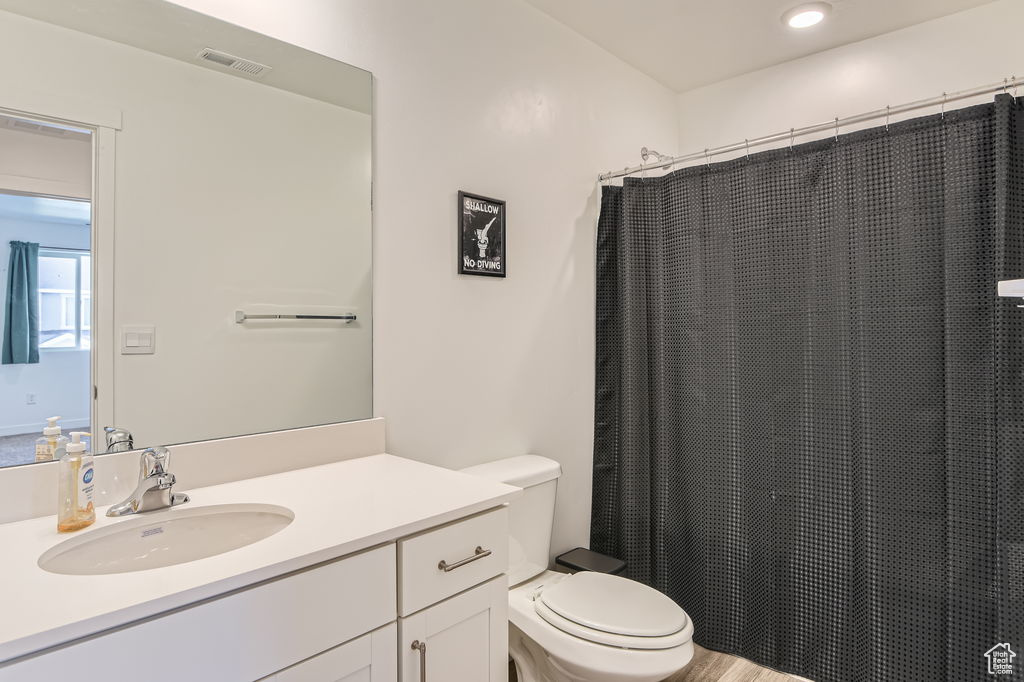 Full bathroom featuring vanity, wood finished floors, and a shower with shower curtain