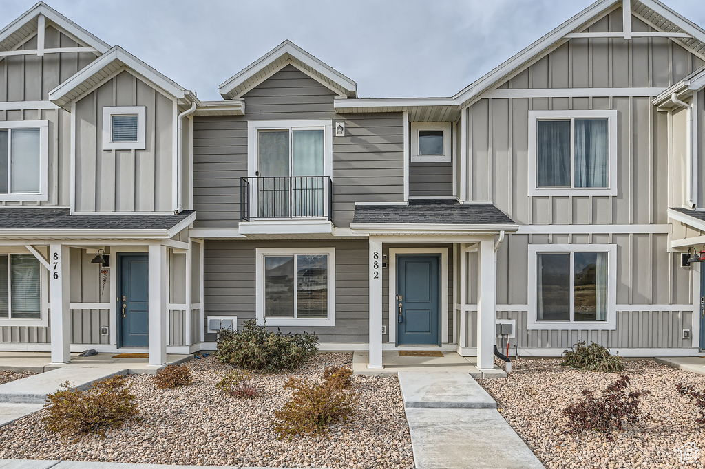 Townhome / multi-family property featuring board and batten siding and a shingled roof