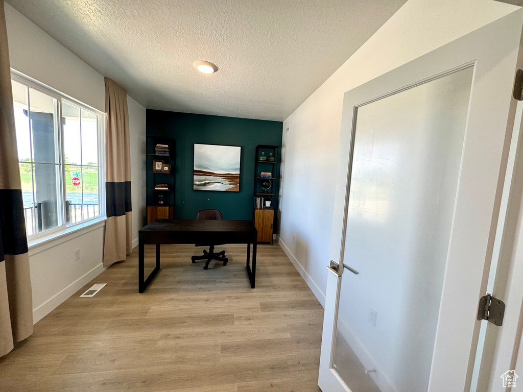 Office area featuring a textured ceiling and light wood finished floors