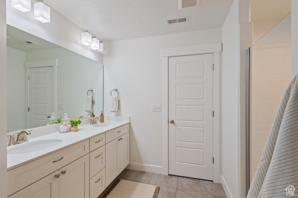 Full bath with double vanity and tile patterned floors