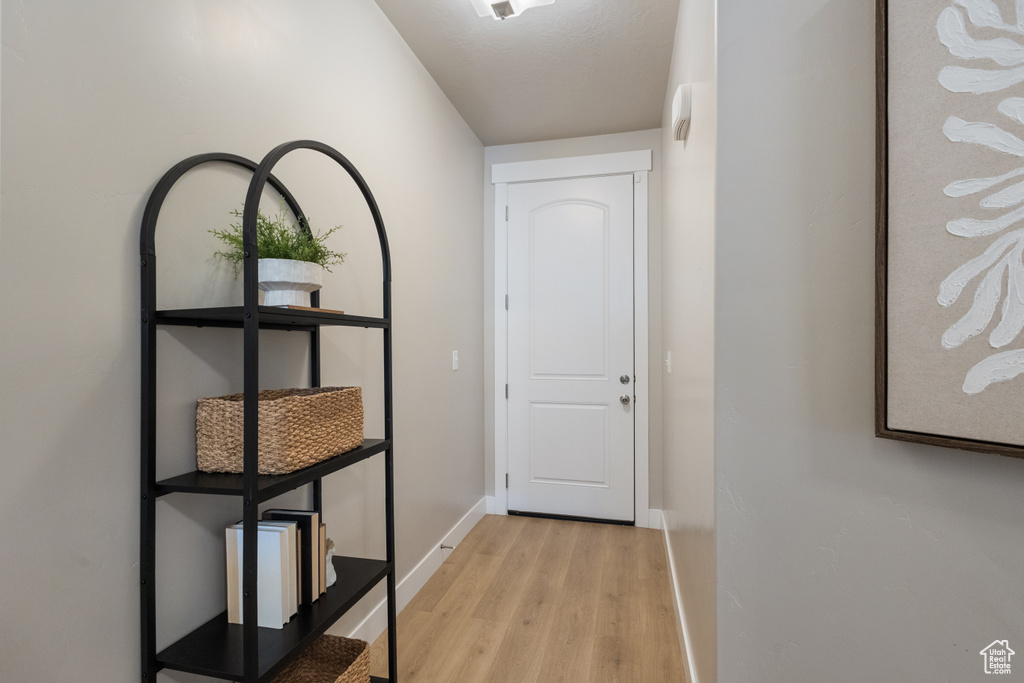 Doorway to outside featuring light wood-type flooring and baseboards