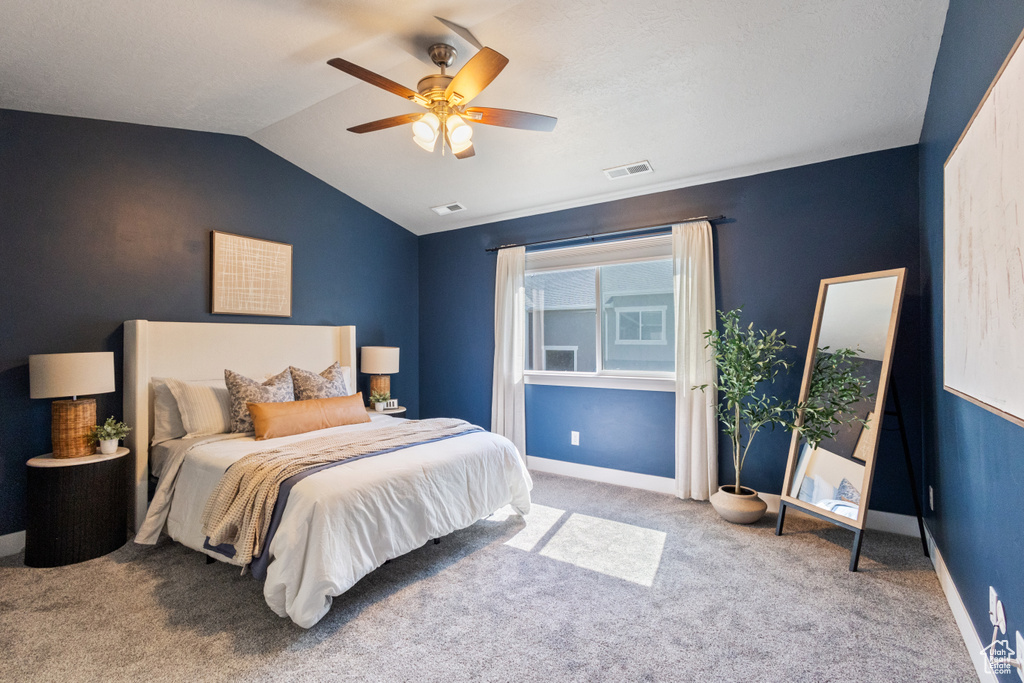 Bedroom with carpet floors, vaulted ceiling, and ceiling fan