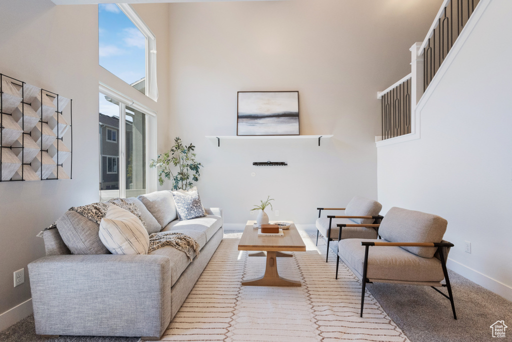 Living room featuring a high ceiling and carpet flooring