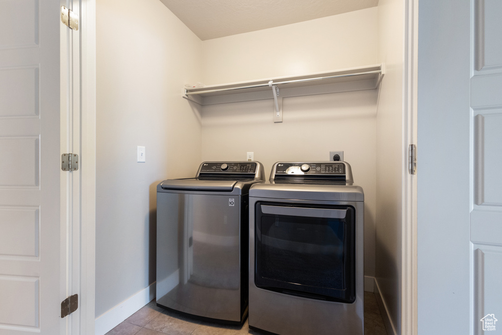 Washroom featuring washer and clothes dryer and baseboards