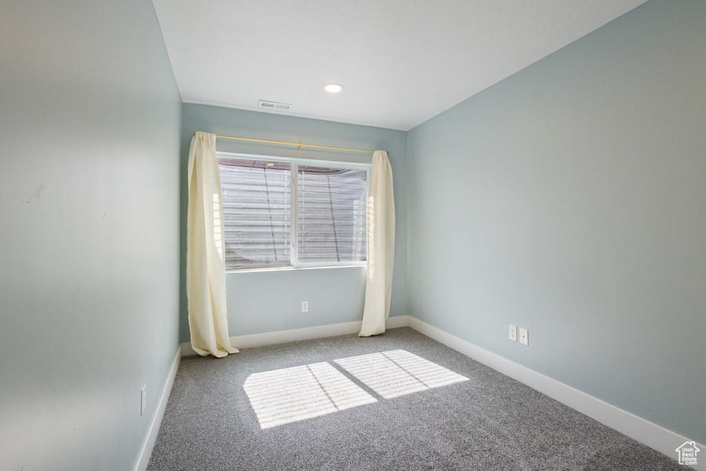 Carpeted empty room with baseboards and recessed lighting