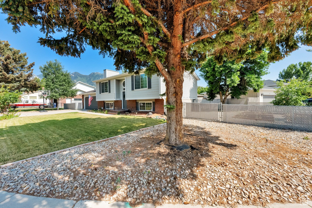 View of front of home with a chimney, brick siding, and a mountain view