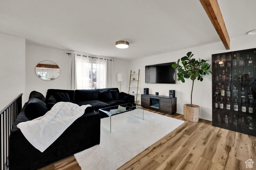 Living room featuring wood finished floors and beamed ceiling