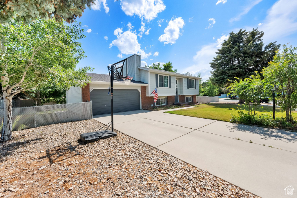 View of front of property featuring driveway, brick siding, and a garage