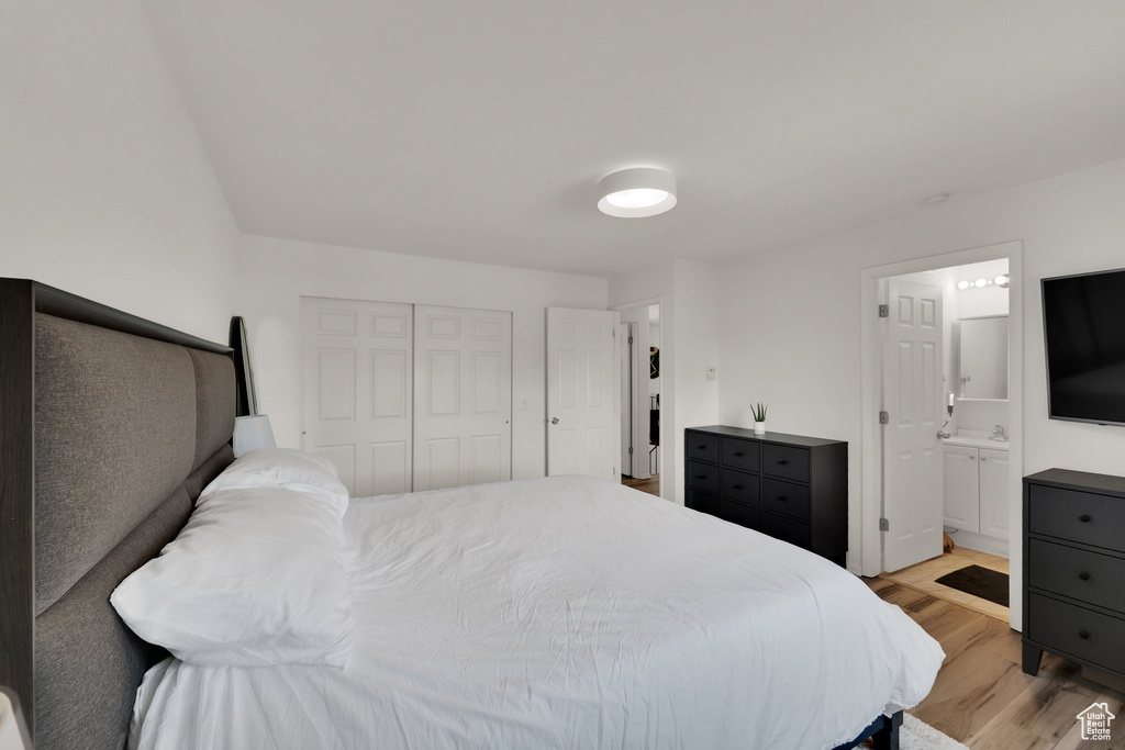 Bedroom featuring light wood-type flooring, a closet, and connected bathroom