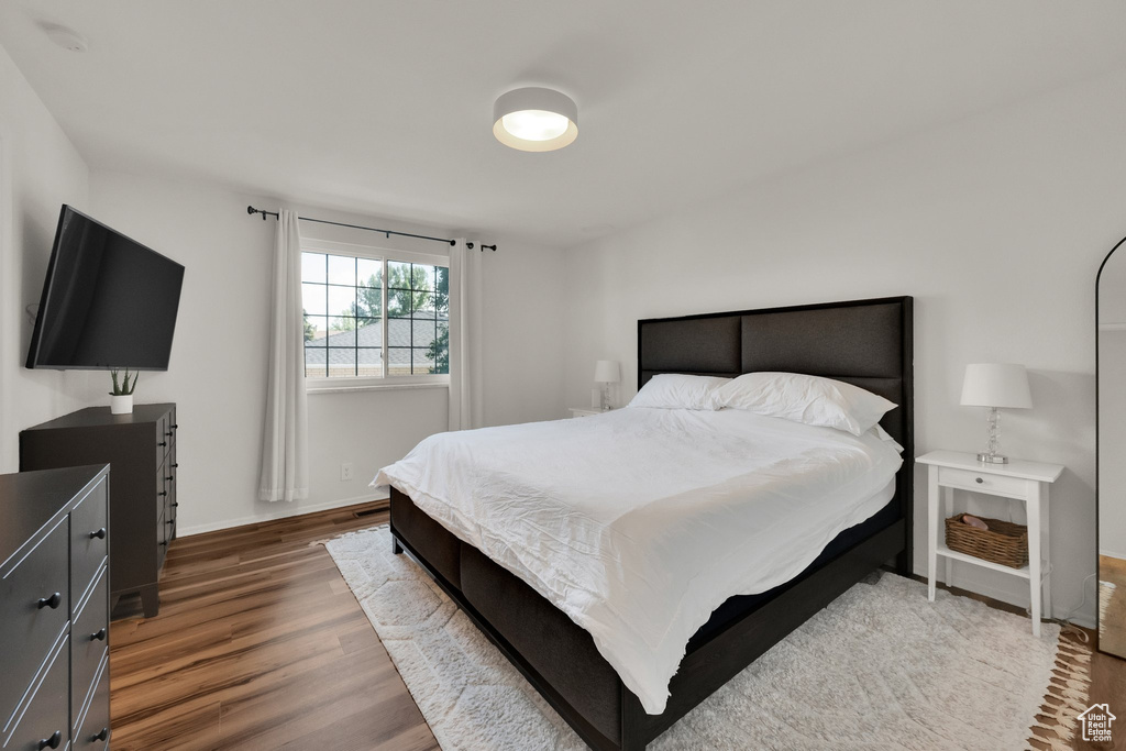 Bedroom with wood finished floors and baseboards