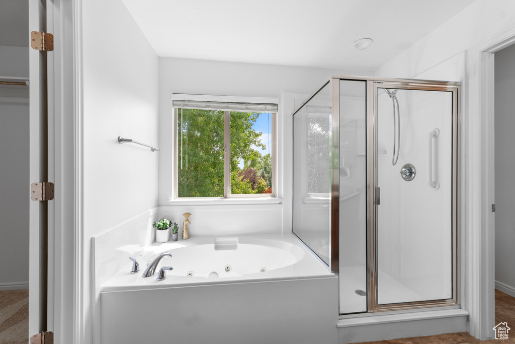 Full bathroom with a shower stall and a jetted tub