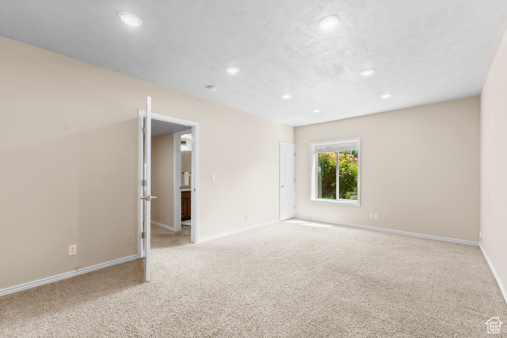 Empty room with recessed lighting and light carpet
