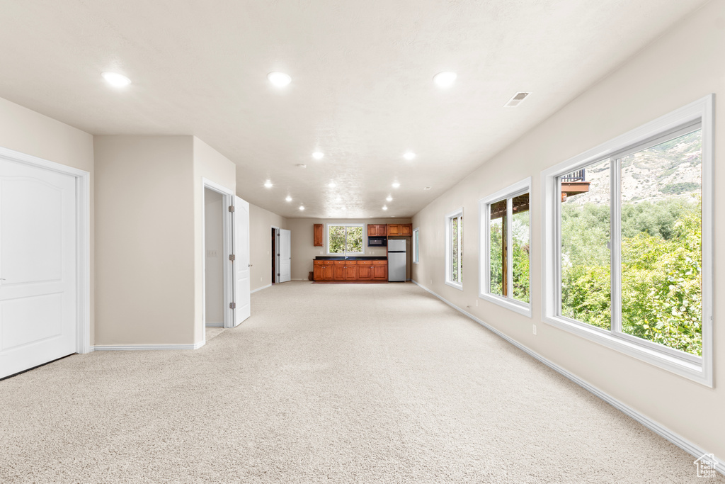 Unfurnished living room with recessed lighting and light colored carpet