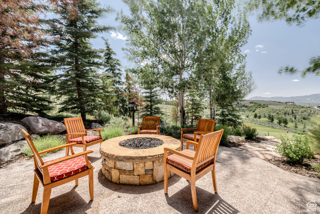 View of patio featuring an outdoor fire pit and a mountain view